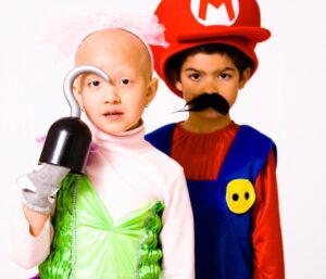 Mia and Iñaki Godoy as toddlers. 
Mia wears a green and pink costume with a pirate hook in her right hand. 
Iñaki wears a Mario costume from the Mario Bros. game.